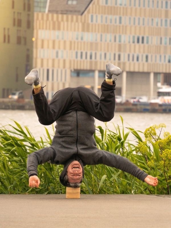 Yuval Oz balancing upside down on one hand, smiling